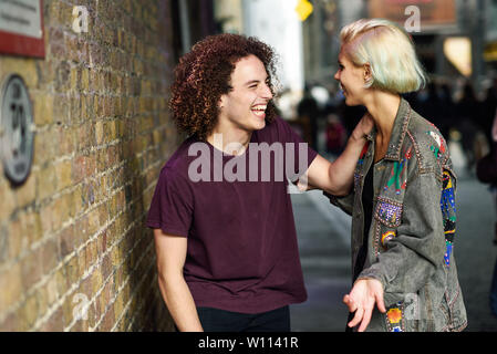 Junges Paar sprechen im städtischen Hintergrund auf ein typisches Londoner Straße.