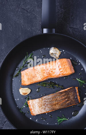 Gegrillter Lachs Steaks in einer Pfanne mit Knoblauch und Rosmarin. Gesunde Ernährung Konzept. Stockfoto