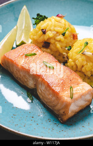 Knusprige Haut gebratener Lachs auf blauen Platte. Gesunde Ernährung Konzept. Stockfoto