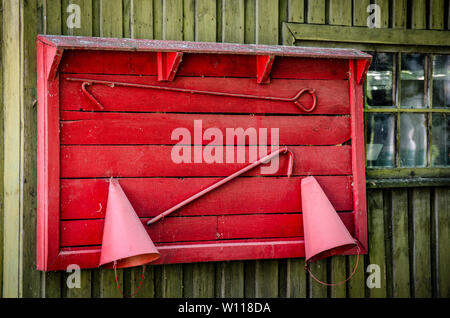 Alte Schutzschild mit einem Werkzeug für Feuerwehrleute. Feuer Schild, hängend auf einer Holz- Oberfläche. Stockfoto