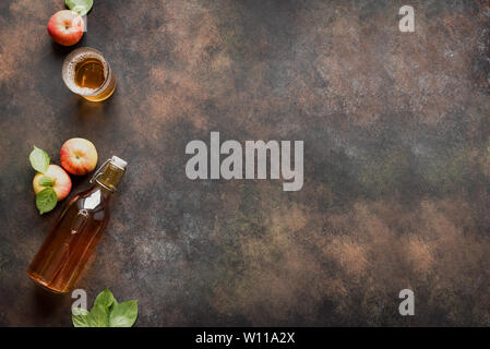 Apple Cider trinken oder vergorenen Obst trinken und organische Äpfel auf dunklen, Ansicht von oben, kopieren. Gesundes Essen und Lifestyle Konzept. Stockfoto