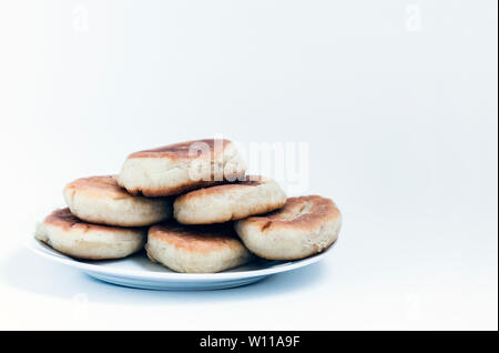 Gebratene Kuchen mit Kartoffeln und Bohnen auf weißem Hintergrund Stockfoto