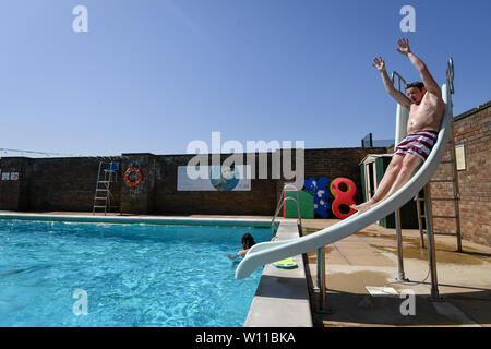 Ein Schwimmer verwendet die Folie am Lido in Chipping Norton, Oxfordshire, an dem Tag, an dem ein neuer Datensatz für einen Juni Temperatur in Großbritannien sehen konnte. Stockfoto