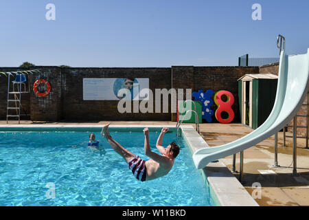 Ein Schwimmer verwendet die Folie am Lido in Chipping Norton, Oxfordshire, an dem Tag, an dem ein neuer Datensatz für einen Juni Temperatur in Großbritannien sehen konnte. Stockfoto