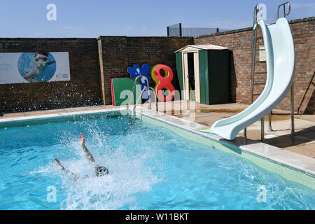 Ein Schwimmer verwendet die Folie am Lido in Chipping Norton, Oxfordshire, an dem Tag, an dem ein neuer Datensatz für einen Juni Temperatur in Großbritannien sehen konnte. Stockfoto