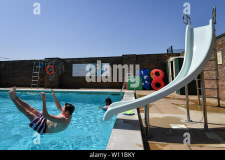 Ein Schwimmer verwendet die Folie am Lido in Chipping Norton, Oxfordshire, an dem Tag, an dem ein neuer Datensatz für einen Juni Temperatur in Großbritannien sehen konnte. Stockfoto