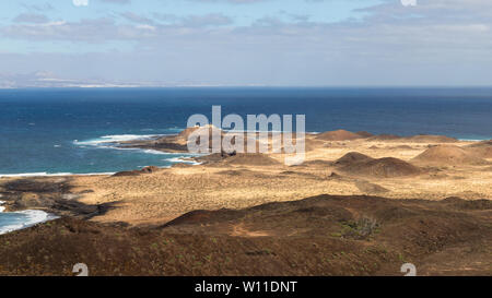 Vulkanische Landschaft auf der Insel Lobos in Fuerteventura, Kanarische Inseln, mit einem Leuchtturm im Hintergrund Stockfoto