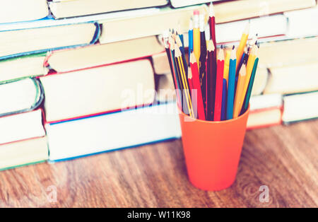 Buntstifte in Halter mit Stack von Buch Bildung Konzept Hintergrund Stockfoto