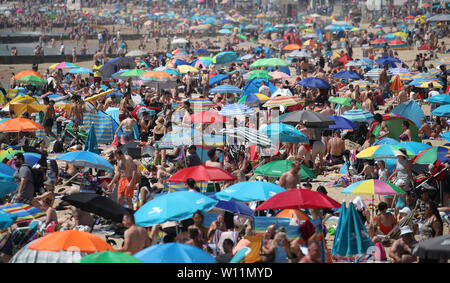 Die Menschen genießen den Sonnenschein und warmes Wetter in Bournemouth in Dorset. Stockfoto