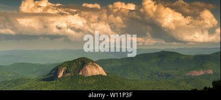 Wunderschöner Panoramablick auf das Foto von Looking Glass Rock bei Sonnenuntergang im Pisgah National Forest umgeben von großen puffy Clouds. Stockfoto