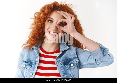 Close-up Schöne positive junge Ingwer lockigen dunkelhaarigen Mädchen verschönern Tag reine aufrichtige Smily weiße Zähne ok ok Zeichen Auge schauen durch optimisti zeigen Stockfoto