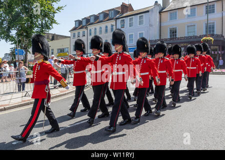 Die Grenadier Guards Parade um Aldershot Town in Hampshire, Großbritannien, in der Feier der Streitkräfte Tag, den 29. Juni 2019. Die Grenadier Guards sind eine der ältesten Regimenter in der Britischen Armee, spezialisiert auf leichte Infanterie, und sind bekannt für ihre roten Tuniken und bärenfellmützen. Stockfoto