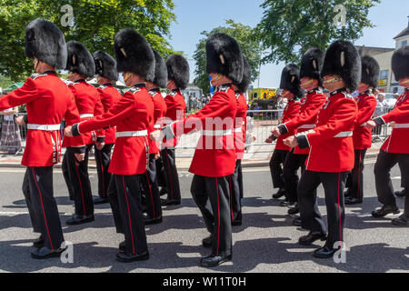 Die Grenadier Guards Parade um Aldershot Town in Hampshire, Großbritannien, in der Feier der Streitkräfte Tag, den 29. Juni 2019. Die Grenadier Guards sind eine der ältesten Regimenter in der Britischen Armee, spezialisiert auf leichte Infanterie, und sind bekannt für ihre roten Tuniken und bärenfellmützen. Stockfoto