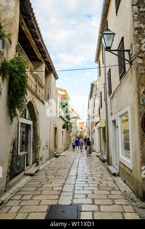 Insel Rab, Primorje-Gorski Kotar/Kroatien - 28. 08. 2014: Blick auf eine schmale Straße auf der Insel mit Touristen wandern und kleine Souvenirläden und Res Stockfoto