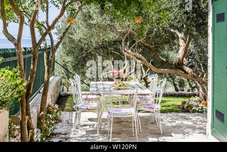 Wunderschöner Garten, Tisch für eine Mahlzeit und Blick auf das Mittelmeer vorbereitet Stockfoto