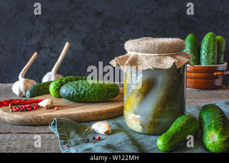 Gewürzgurken mit Kräutern und Gewürzen auf dunklem Hintergrund Stockfoto