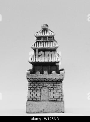Chinesisches Miniaturmodell auf grauem Atelierhintergrund, schwarz-weißes Stillleben einer asiatischen Architekturfigur. Stockfoto