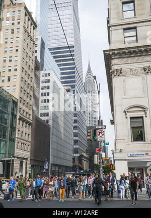 Massen von Menschen warten 5. Avenue an der 42. Straße mit den ikonischen Chrysler Gebäude im Hintergrund ein paar Blocks Kreuz im Osten. Stockfoto