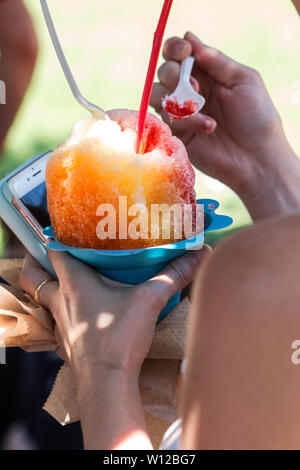 Woman's Hand hält giant Schnee Konus an Ice Cream Festival. Stockfoto