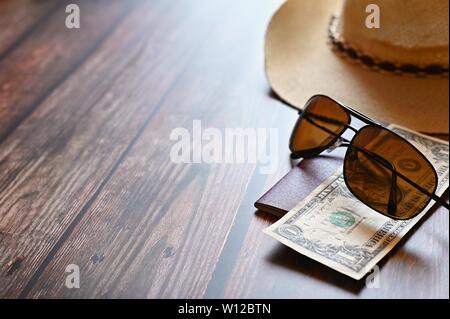 Produkte für Sommerferien: eine Kamera, Reisepass, Smartphone, Geld, Hut, Sonnenbrille. Holz- Hintergrund, Ansicht von oben mit Platz kopieren. Schönen Sommer anhand von quantitativen Simulatio Stockfoto