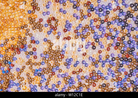 Mehrfarbige Glas Seedbeads auf einem weißen Hintergrund. Stockfoto