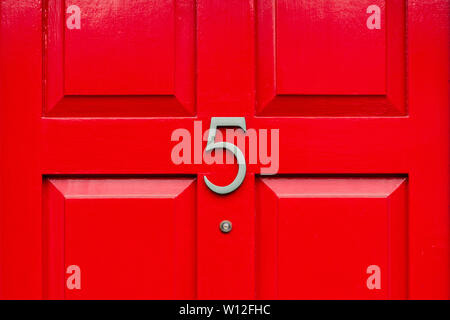 Haus Nummer fünf mit dem 5 in Bronze auf einem hellen Rot Holz- Vordertür Stockfoto