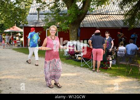 Pizza auf dem Bauernhof, die an den Relationen geliefert, Besucher touring Farm, Musik hören, essen Pizza an Squash Blossom Farm, Oronoco, Minnesota, USA. Stockfoto