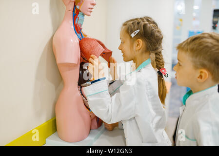 Süße Mädchen und junge spielt Doktor am Dummy Stockfoto