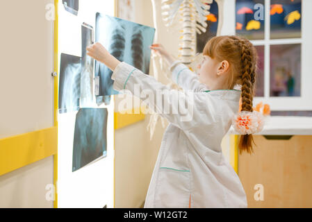 Kleine Mädchen in Uniform sieht sich die x-ray, Arzt Stockfoto