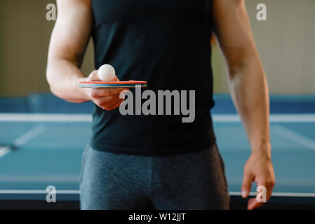 Männliche Person hält Schläger und Ping Pong Ball auf Sie Stockfoto