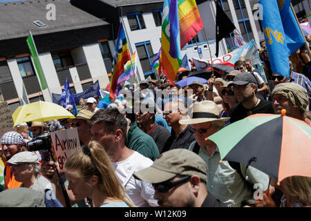 Ramstein, Deutschland. 29. Juni 2019. Die demonstranten hören sich die Redner bei der Eröffnung Rallye. ein paar tausend Friedensaktivisten aus dem Stopp der Air Base Ramstein Kampagne protestierte außerhalb der US-Airbase in Ramstein. Der Protest war das Ende der diesjährigen Aktionswoche gegen die Airbase. Im Mittelpunkt der Veranstaltungen in diesem Jahr war die angebliche Beteiligung der Airbase in die drone Kriegsführung der US Air Force im Nahen Osten und in Afrika und Anruf Ramstein nicht für einen künftigen Krieg mit dem Iran. Stockfoto