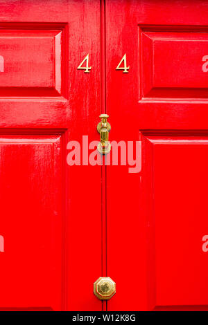 Das Haus Nummer 44 auf einem hellen Rot bemalten Tür mit den vierzig gesehen - Vier in Metall Ziffern Stockfoto