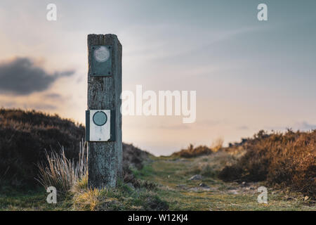 Eine leere Wegweiser in einem Nationalpark in Großbritannien mit einer Ruhe Sonnenuntergang hinter es Stockfoto