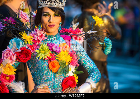 NEW YORK CITY - 25 Juni, 2017: eine transgender drag Performer tragen Blumen mit ihrer Schönheit Königin tiara Pässe auf einen Schwimmer im LGBTQI Pride Parade. Stockfoto