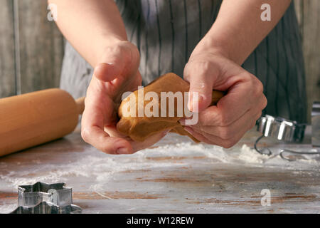 Die Frau Hände mash Lebkuchen Teig auf dem Tisch Stockfoto