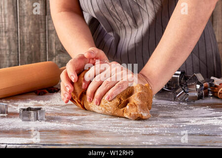 Die Frau Hände mash Lebkuchen Teig auf dem Tisch Stockfoto