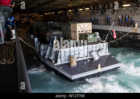 190629-N-DX 072-1077 CORAL SEA (29. Juni 2019) Landing Craft, Utility (LCU) 1666, zugeordnet zu den Naval Beach (NBU) 7, trägt das Deck des amphibious Transport dock Schiff USS Green Bay LPD (20). Green Bay, Teil der Wasp Amphibious Ready Group, mit 31 Marine Expeditionary Unit in Angriff genommen, ist die in der indopazifischen Region Interoperabilität mit Partnern zu verbessern und dienen als ready-Response Force für jede Art von Kontingenz, und stellen gleichzeitig eine flexible und tödliche Krise Response Force bereit, eine breite Palette von militärischen Operationen auszuführen. (U.S. Marine Foto von Masse Stockfoto