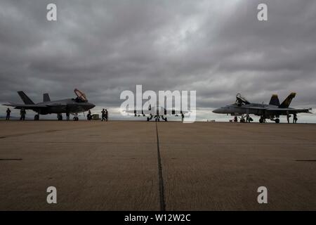 Eine F-35C Lightning II und zwei F/A-18C Hornet mit Marine Fighter Attack Squadron (Vmfa) 314, Marine Aircraft Group (MAG) 11, 3. Marine Flugzeugflügel (MAW), während einer Sonne Zeremonie auf der Marine Corps Air Station Miramar, Calif., 21. Juni 2019 angezeigt werden. Die Staffel hielt die Zeremonie der F/A-18C Hornet aus ihren Reihen sich zurückziehen und die F-35C Lightning II als Ihr neues Betriebssystem Flugzeuge vorstellen. (U.S. Marine Corps Foto von Lance Cpl. Jaime Reyes) Stockfoto