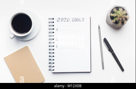 Ziele Liste im Notizblock mit Stift und Tasse Kaffee auf Weiß Stockfoto