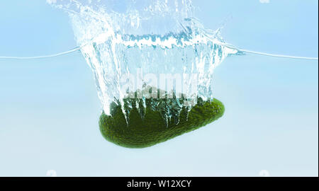 Reife Avocado in das Wasser sinken mit Blasen Stockfoto
