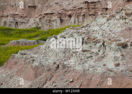 Dramatische Gebirgsformationen geschnitzt aus Ebenen durch Erosion von Gesteinen mit Spring wildflowers unten in Badlands National Park, South Dakota. Stockfoto