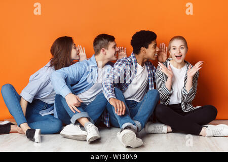 Gruppe von Freunden flüstern einander im Ohr Stockfoto