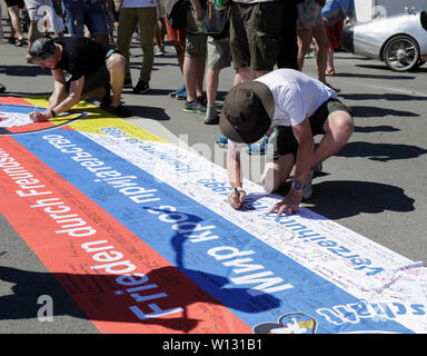 Ramstein, Deutschland. 29 Juni, 2019. Eine Demonstrantin Zeichen seinen Namen auf einen Frieden Banner. ein paar tausend Friedensaktivisten aus dem Stopp der Air Base Ramstein Kampagne außerhalb der US-Airbase Ramstein protestiert. Der Protest war das Ende der diesjährigen Aktionswoche gegen die Airbase. Im Mittelpunkt der Veranstaltungen in diesem Jahr war die angebliche Beteiligung der Airbase in die drone Kriegsführung der US Air Force im Nahen Osten und in Afrika und Anruf Ramstein nicht für einen künftigen Krieg mit dem Iran. Quelle: Michael Debets/Pacific Press/Alamy leben Nachrichten Stockfoto