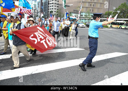 Osaka, Japan. 29 Juni, 2019. Ein Polizist, der den Verkehr zu stoppen, während eine Gruppe von Menschen gegen die Osaka G20-Gipfel protestieren 2019 vorbei. Die Gruppe der 20 Gipfel war am 28. Juni und 29. Foto am Samstag, 29. Juni 2019 übernommen. Foto: Ramiro Agustin Vargas Tabares Credit: Ramiro Agustin Vargas Tabares/ZUMA Draht/Alamy leben Nachrichten Stockfoto