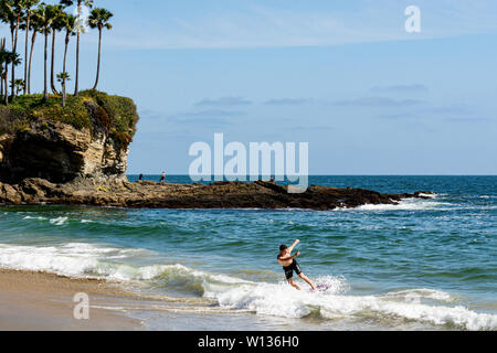 Laguna Beach, CA/USA - Mai 4, 2019: Ein junger Mann skimboards in Laguna Beach, in dem der Sport entstanden. Stockfoto