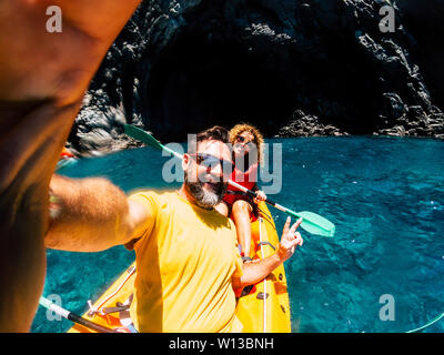 Gerne fröhliche Menschen im Freien Freizeitaktivität im Kajak an der Küste Ozean - selfie Bild mit netten Paar - Höhle und ocean Hintergrund und Stockfoto