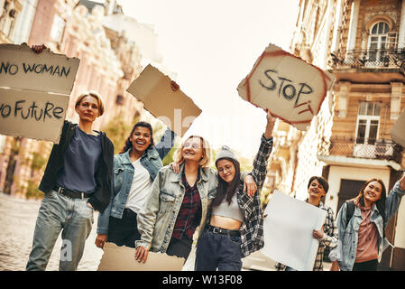 Girl Power. Gruppe junger und glücklich Aktivistinnen auf der Straße während der demonstrationszug und halten Schilder mit verschiedenen Slogans. Menschenrechte. Protest Konzept. Rechte der Frau Stockfoto