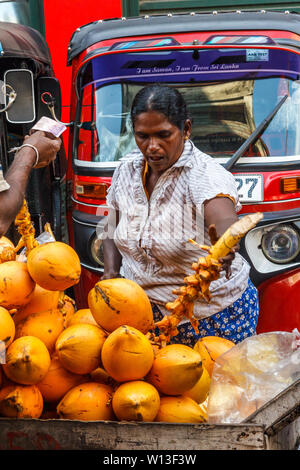 Colombo. Sri Lanka - 21. Dezember 2016: Frau kauft Kokosnüsse in den Pettah Bezirk. Dies ist das wichtigste Geschäftsviertel. Stockfoto