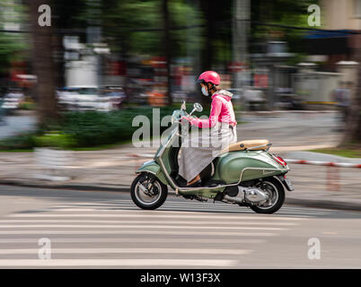 Ho Chi Minh City, Vietnam - Januar 11, 2016: Junge Frau, die ihrem eleganten Vespa Roller in der Innenstadt von Ho Chi Minh Stadt. Stockfoto
