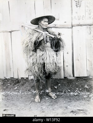 [1890s Japan - Japanische Bauer mit Hoe] - Landwirt mit einem kiseru Rohr, das Tragen eines Mino (Stroh regenmantel) und einem sugegasa konische Hut. Er ist mit einer Hacke über die Schulter. 19 Vintage albumen Foto. Stockfoto